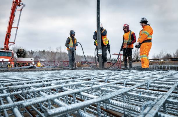 Concreting a bridge slab using a concrete pump during winter Val-St-Gilles, Quebec, Canada, 2022-11-25, Concreting a bridge slab using a concrete pump during winter rebar production stock pictures, royalty-free photos & images