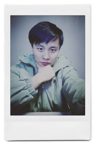 A man is taking a selfie with a Polaroid