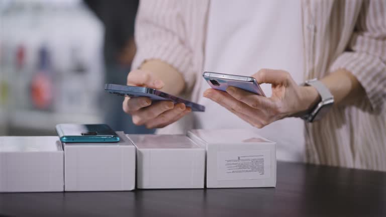 Hands and smartphone close-up. A woman in a gadget store, choose a new smartphone.