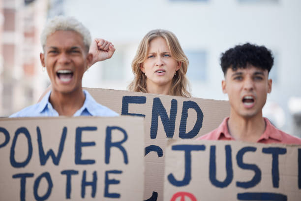 istock Angry, activism and activist group protest racism, oppression and human rights violation with poster. Diverse students, fist and rally together for unity and civil rights, justice and revolution. 1445793376