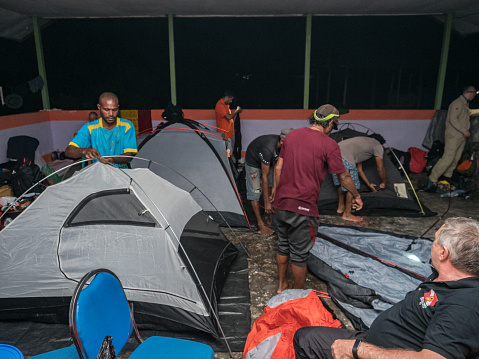 Kensi, Arguni, Indonesia - Feb, 2018: Group of traveller are preparing campground inside a building without walls during an expedition in the rainforests of Indonesia Bird's Head Peninsula, West Papua