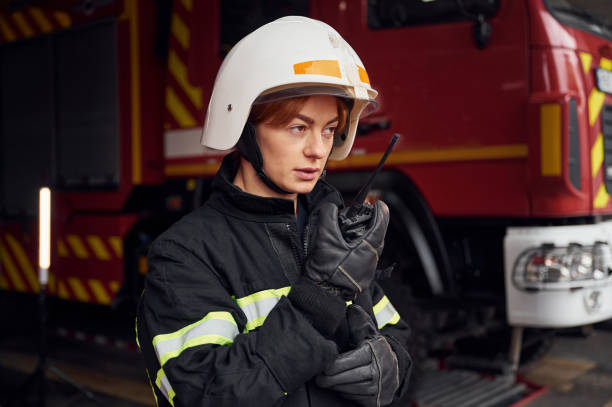 istock Talking by using radio transmitter. Woman firefighter in uniform is at work in department 1445793951