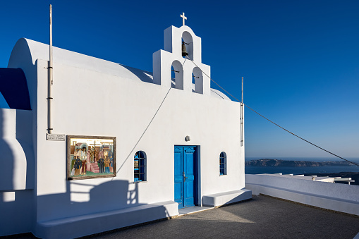 Imerovigli, Santorini, Greece - June 29, 2021: Beautiful white traditional greek ortodox church in Imergovigli on Santorini island, Greece.