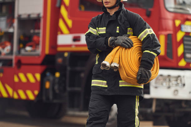istock Holding fire hose. Woman in uniform is at work in department 1445794852