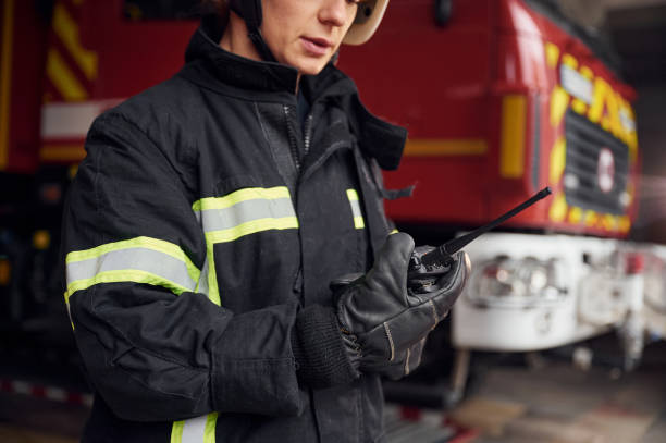 istock Using radio transmitter. Woman firefighter in uniform is at work in department 1445795431