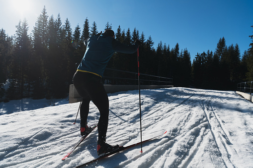 Nordic skiing or Cross-country skiing classic technique practiced by man in a beautiful panoramic trail at morning. High quality photo