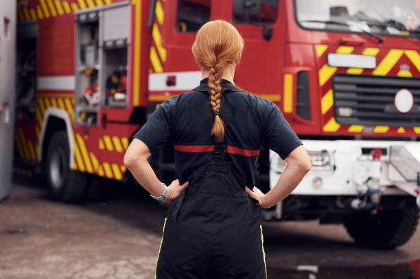 istock Rear view. Woman firefighter in uniform is at work in department 1445797122