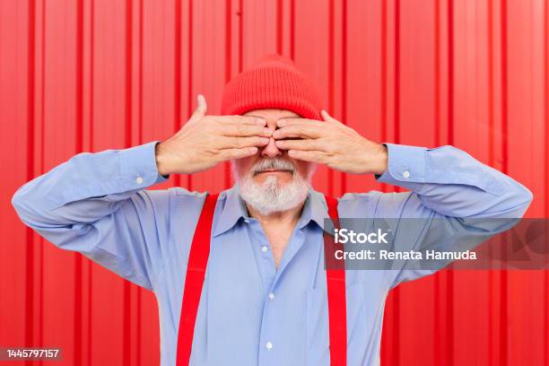 An Elderly Man Covering His Eyes With His Hands On Red Background Stock Photo - Download Image Now