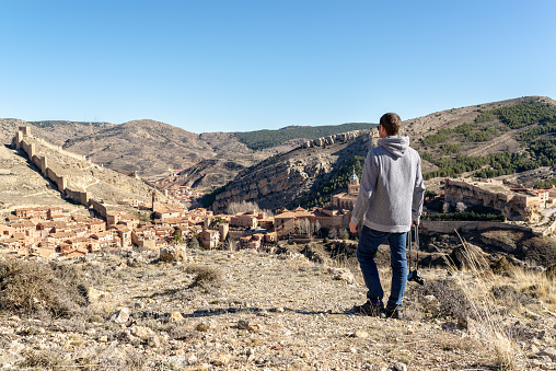 Adventure photographer looking at Albarracín, beautiful medieval village in Spain.