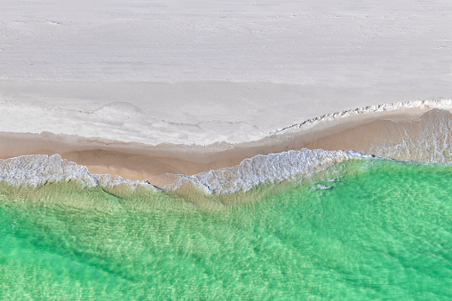 Waters breaking on a beach along the Gulf of Mexico on the panhandle of Florida, USA near Pensacola shot from directly above.