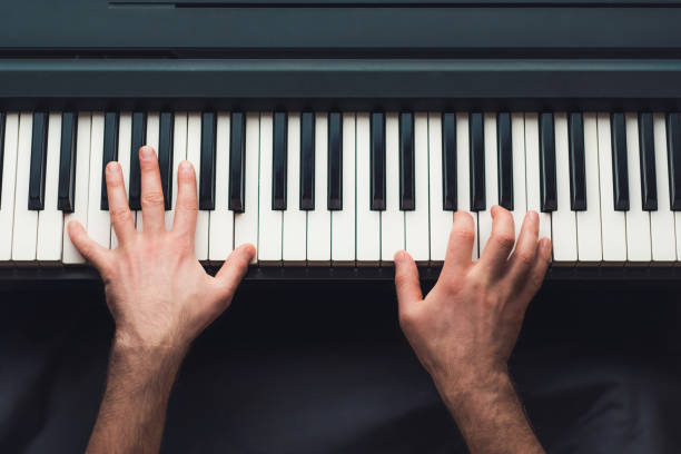 uomo che suona il pianoforte - pianoforte foto e immagini stock