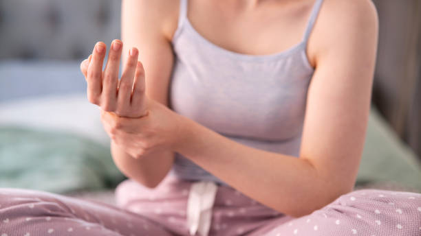 woman suffering her ache from wrist pain, numbness, or hand holding stock photo
