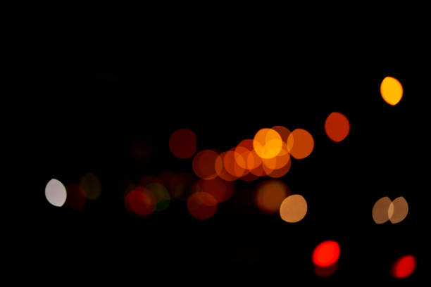 istock Abstract glowing bokeh lights highlighted on a black background. Festive golden glowing background with yellow lights. Overlay bokeh for your design. 1445805714