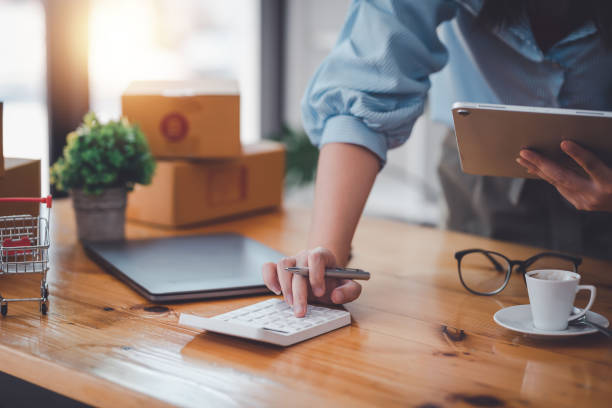 istock Business owner press a calculator with holding tablet in the office. 1445806206