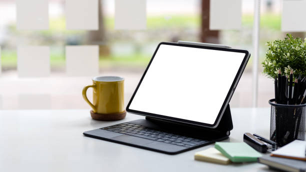 Tablet with keyboard blank white screen of placed on office table. Mock up.