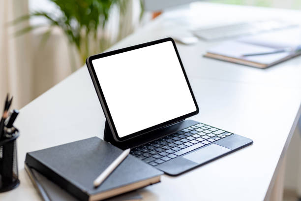 istock Tablet with keyboard blank white screen of placed on office table. Mock up. 1445806363