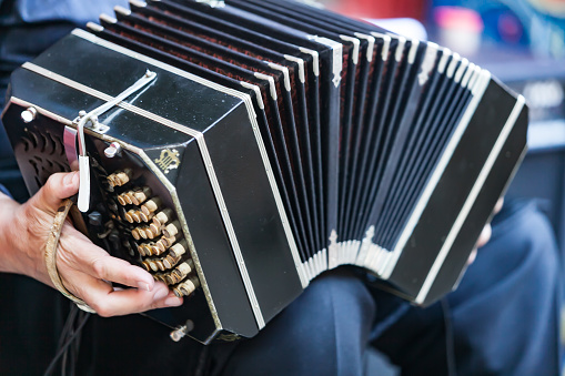 Lisbon, Portugal - December 17, 2022: A street musician plays an accordion at the Rua Augusta street in Lisbon downtown.