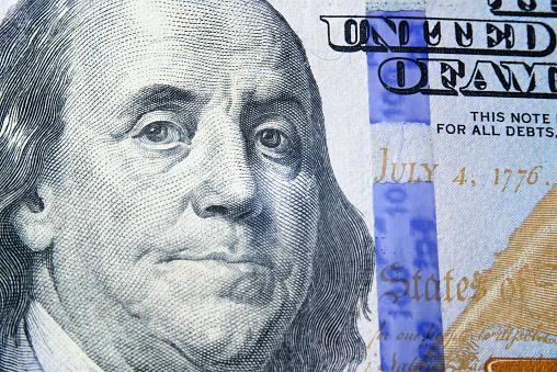 closeup of one hundred dollars on wooden table