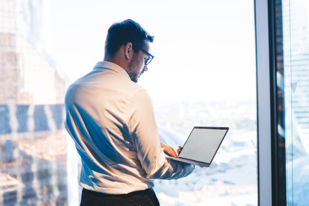 istock Businessman working on laptop against window in office 1445812316