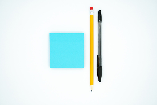 Pencil, pen and blue blank sticky notes, isolated on white background.