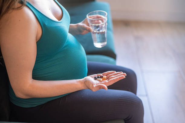 istock Pregnant woman taking nutritional supplement capsules 1445815621