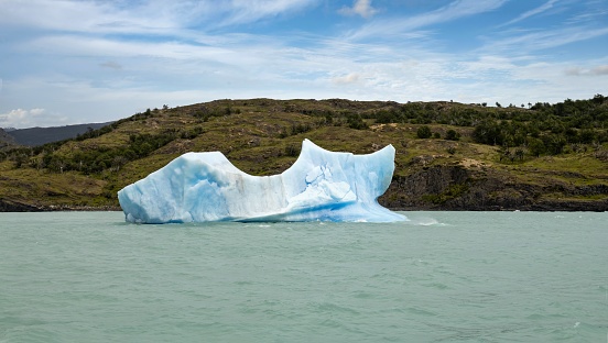 Punta Bandera, Argentina, November 2, 2019: A floe of ice floats on the surface of the Lake Argentino (Lago Argentino). It is the biggest freshwater lake in Argentina, with a surface area of 1,415 km2 and a maximum depth of 500 m. The Lake is situated in Los Glaciares National Park which was declared a World Heritage Site by UNESCO in 1981.