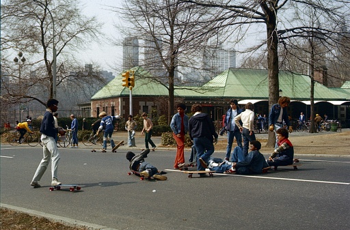 New York City, NY, USA, 1978. Group of young skateboarders practicing with their boards on a street in New York's Central Park.