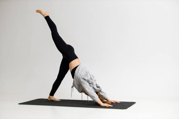 istock A woman is engaged in yoga on a white background, stretching training. 1445819418