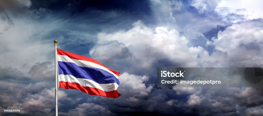 Thai flag at flagpole over storm clouds Waving Thai flag at flagpole Above Stock Photo