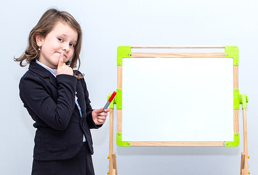 Child, schoolgirl girl on the background of a gray wall