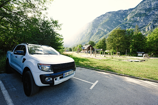 Ukanc, Slovenia - July, 03, 2022: White Ford Ranger on parking against Julian Alps, Ukanc, Slovenia.