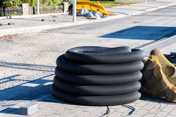tubo ondulado preto enrolado em uma bobina em um canteiro de obras. - sewer driveway brick paving stone - fotografias e filmes do acervo