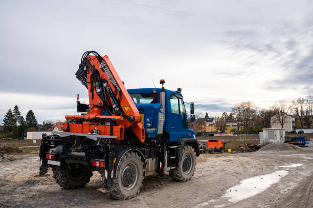 istock A car with an orange manipulator crane is standing on a construction site. 1445823287