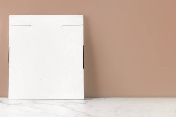 istock Empty cardboard box, white flat packaging bag. Blank, mock up. Beige was and marble background. 1445824094