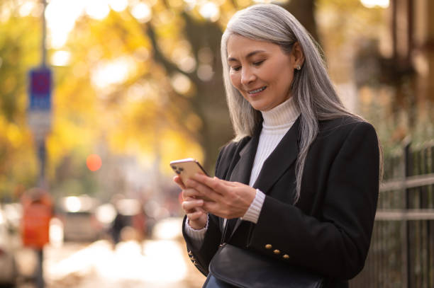 istock Long-haired mid aged woman with a smartphone looking anticipated 1445824703