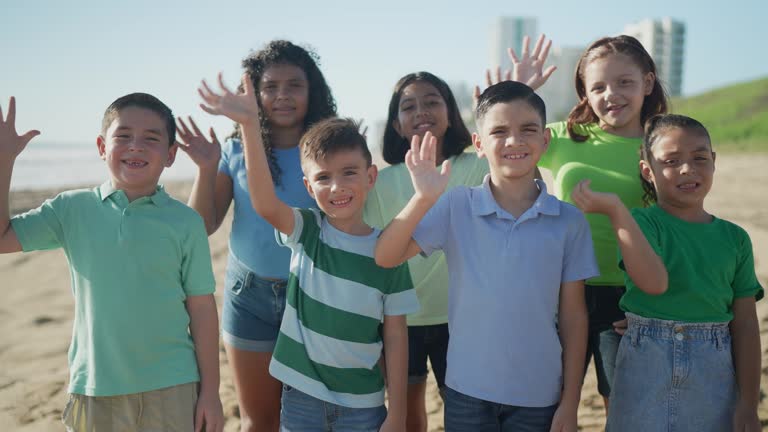 Portrait of group children waving at the beach