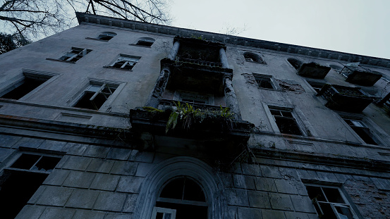 An old abandoned building.Action. A dark building with broken and empty windows inside which there is nothing against the white background of the sky. High quality 4k footage