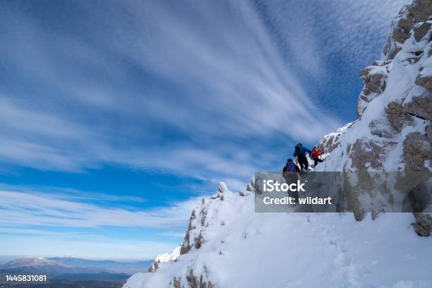 Successful Mountain Climber Team Is Climbing To The Summit Of A Mountain In Winter Stock Photo - Download Image Now