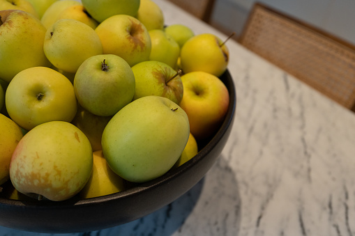 Bowl of apples on marble table in home