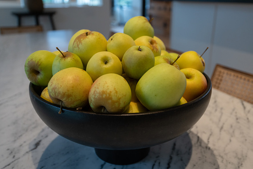 Bowl of apples on marble table in home