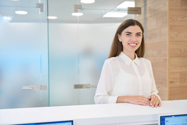istock Smiling happy female visitor posing for camera at front desk 1445836490