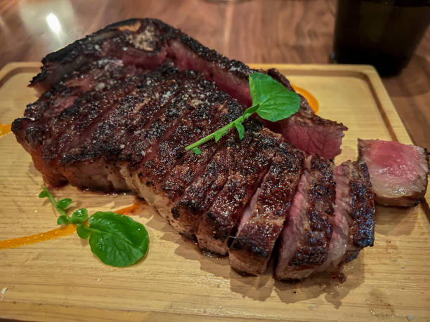 istock Close up, selective focus on a cooked steak on a wood cutting board 1445836738