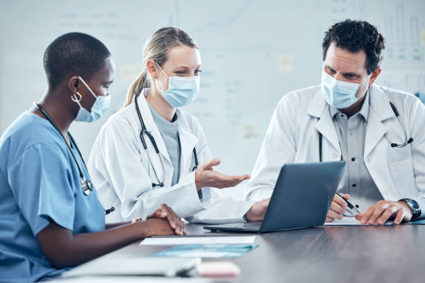 Covid, healthcare and laptop with a doctor and nurse team working in a hospital on planning or strategy in a meeting. Computer, collaboration and medical with a group of health workers in a clinic covid, atención médica y computadora portátil con un equipo de médicos y enfermeras que trabajan en un hospital en planificación o estrategia en una reunión. informática, colaboración y medicina con un grupo de trabajadores de la salud en una clín
