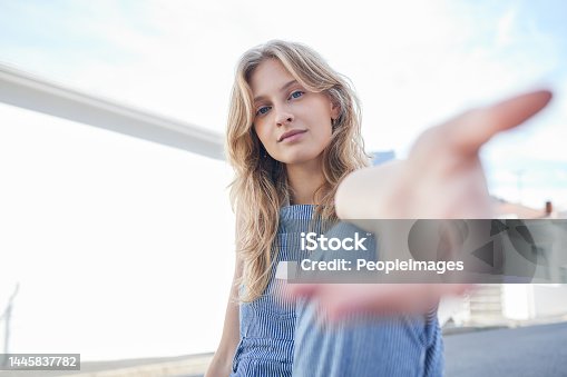 istock Portrait of girl in the city with hand reaching forward, sitting in the street. Student, education and young woman in college with hands out in urban road. Motivation, encourage and freedom in youth 1445837782