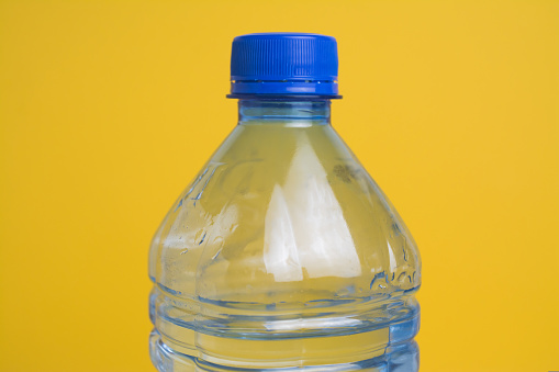 Plastic water bottle on yellow background