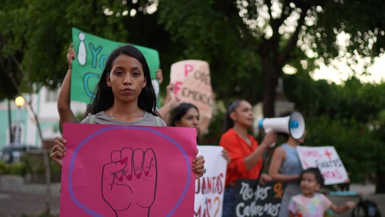 Portrait of young proster woman holding a poster during a feminism protest