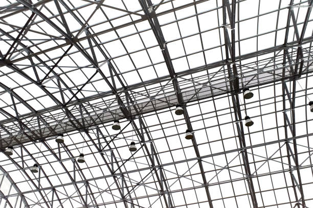 Metal geometric structure supporting a glass transparent roof. The architecture of a ceiling modern building with lamp lights and natural lighting
