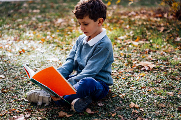 istock Very expressive child reads a book in the park 1445850466