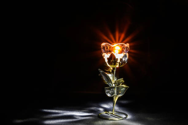 candlestick in the form of a flower with a candle in the dark on a black background