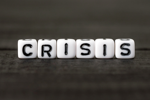 Word crisis from white cubes on black background. Business financial instability. Economic concept.